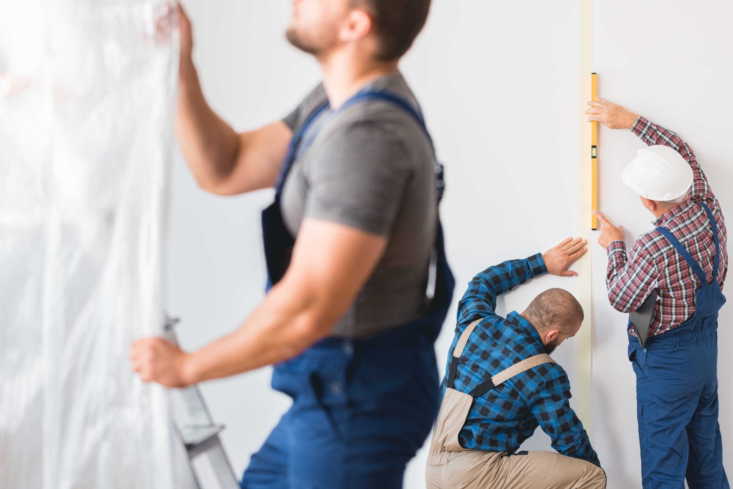 Multiple Dubai tradespeople including a painter, plumber, and handyman working in different areas of a home at the same time.