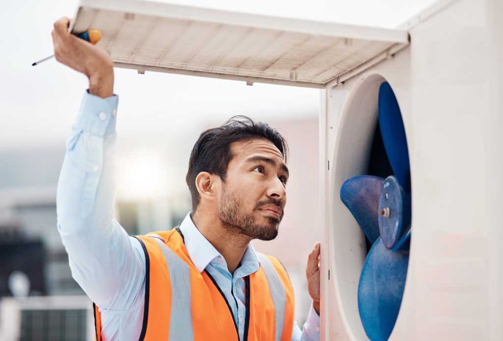 Dubai technician using a digital meter to check AC airflow during preventive maintenance, ensuring optimal cooling and reliable performance.