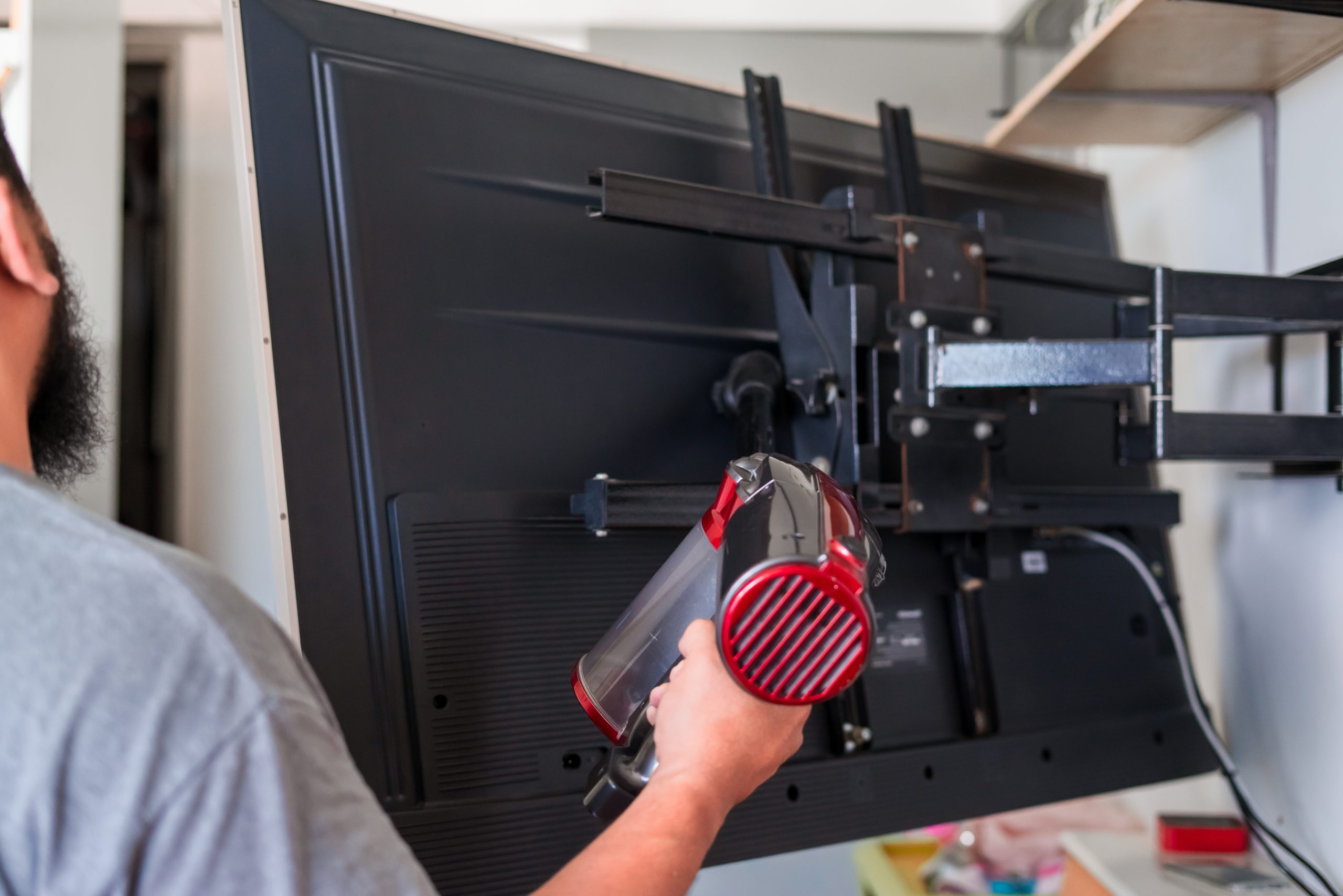 Dubai carpenter mounting a TV on the wall using a spirit level for accuracy, delivering clean and precise finishing touches.