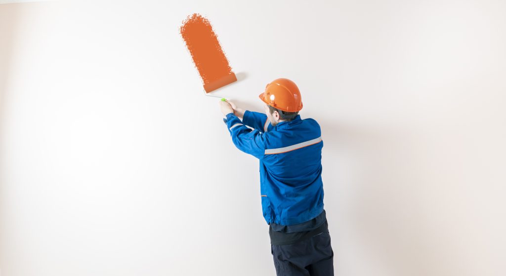 wall repair and painting UAE technician applying protective coating to wall