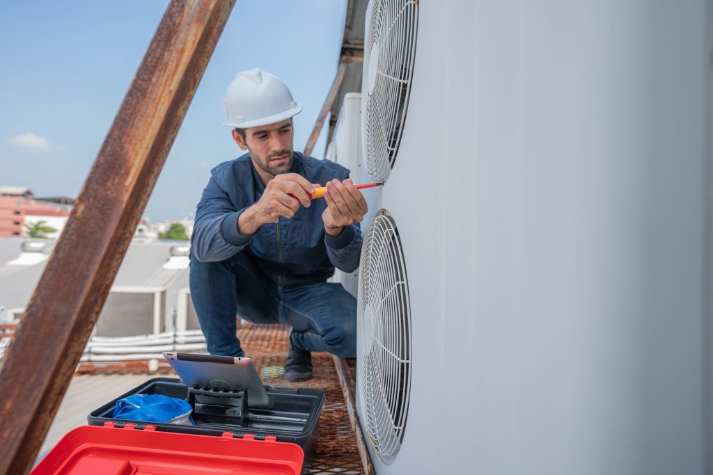 Technician repairing AC during home maintenance in UAE.