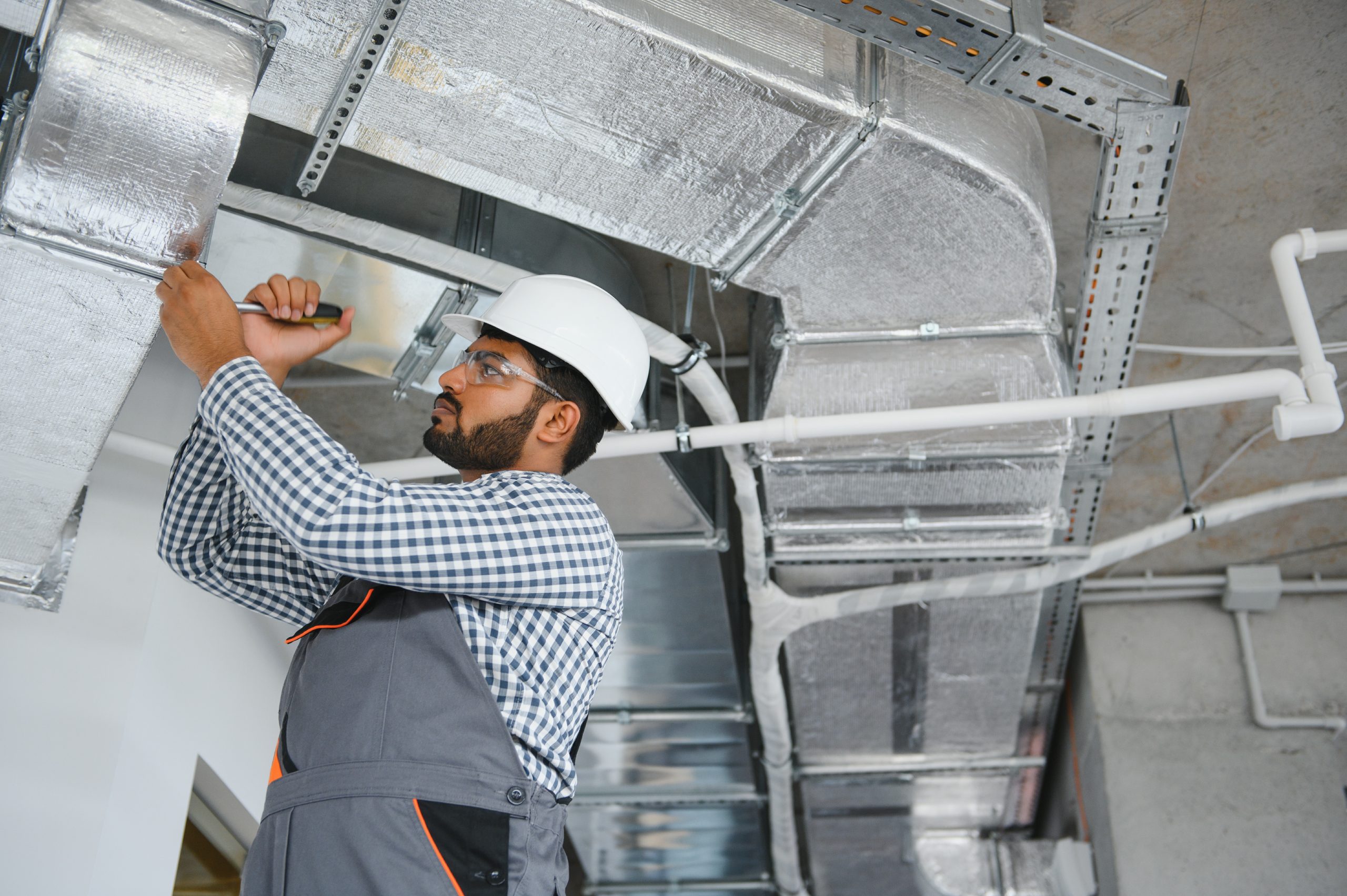Licensed AC cleaning Ajman technician inspecting duct interior using camera.
