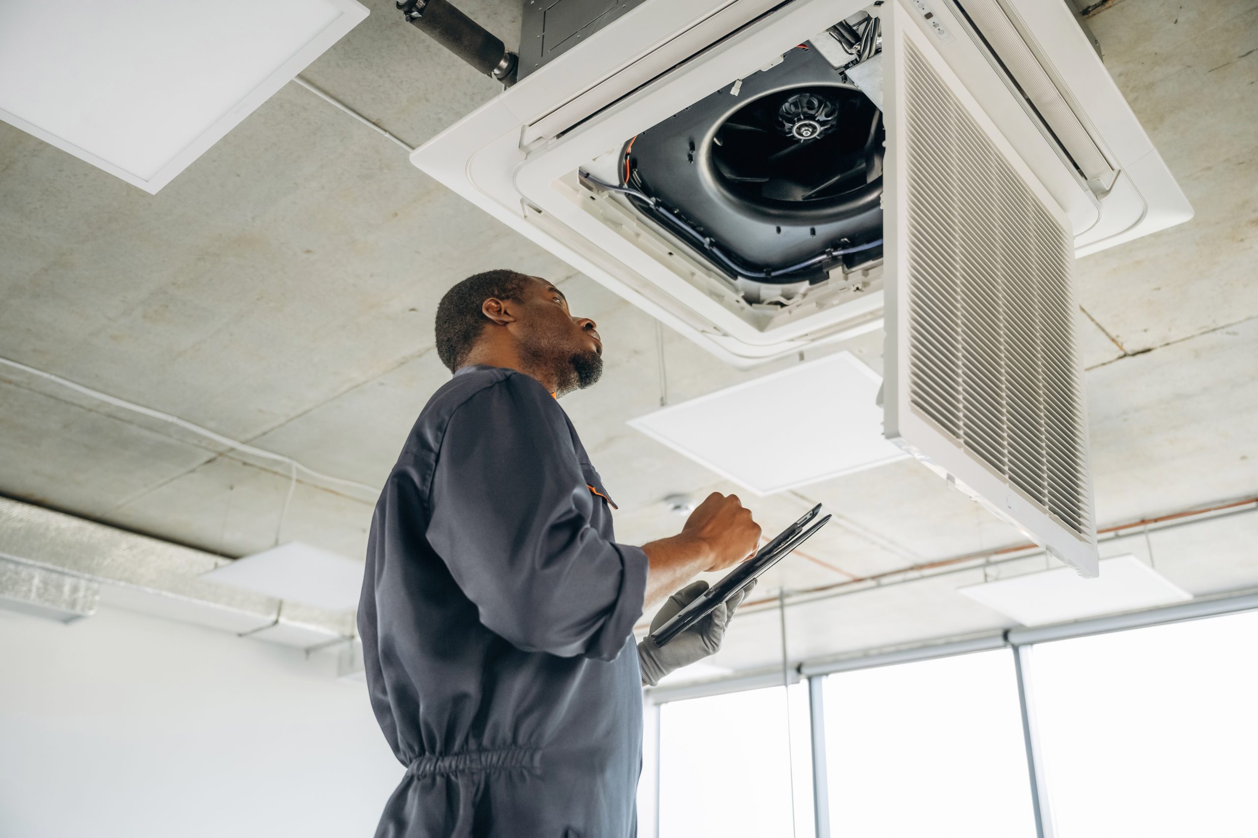 UAE AC technician inspecting indoor air conditioning system during detailed inspection.