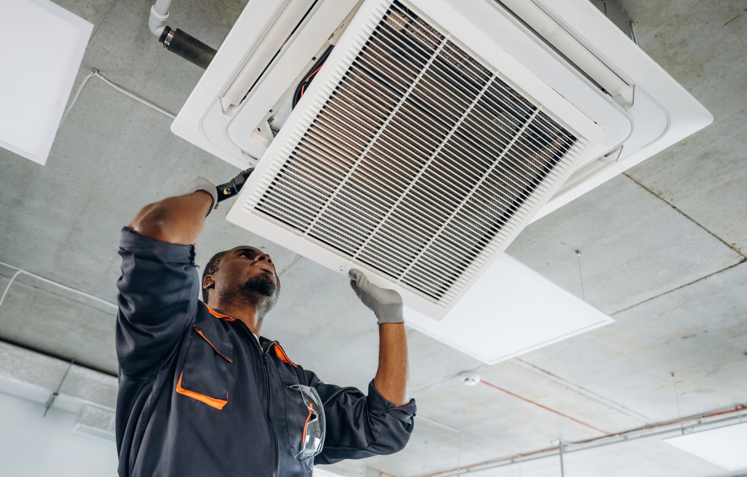 Licensed AC coil cleaning Abu Dhabi specialist applying eco-friendly solution to dirty evaporator coils for safe deep cleaning.