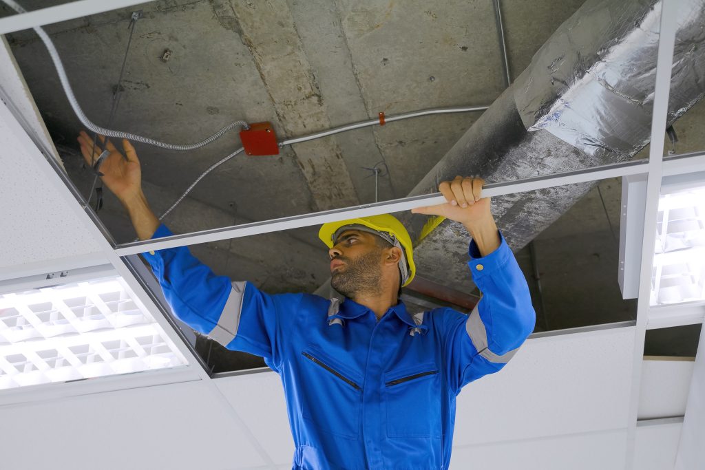 AC duct sanitization Ajman service technician holding sanitization tools inside home.