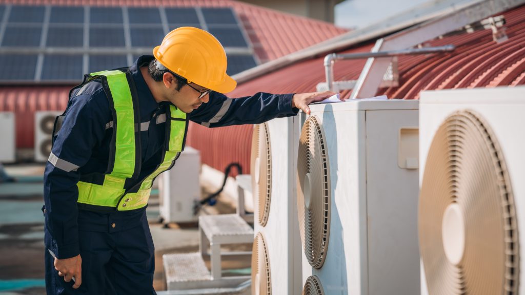 Same-day AC maintenance Abu Dhabi technician in uniform holding AC tools.