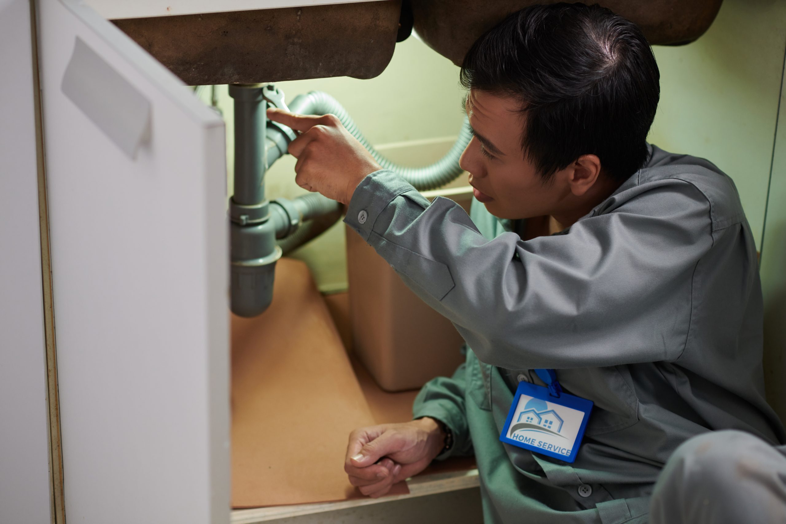 Kitchen plumbing Sharjah expert repairing sink in residential property.