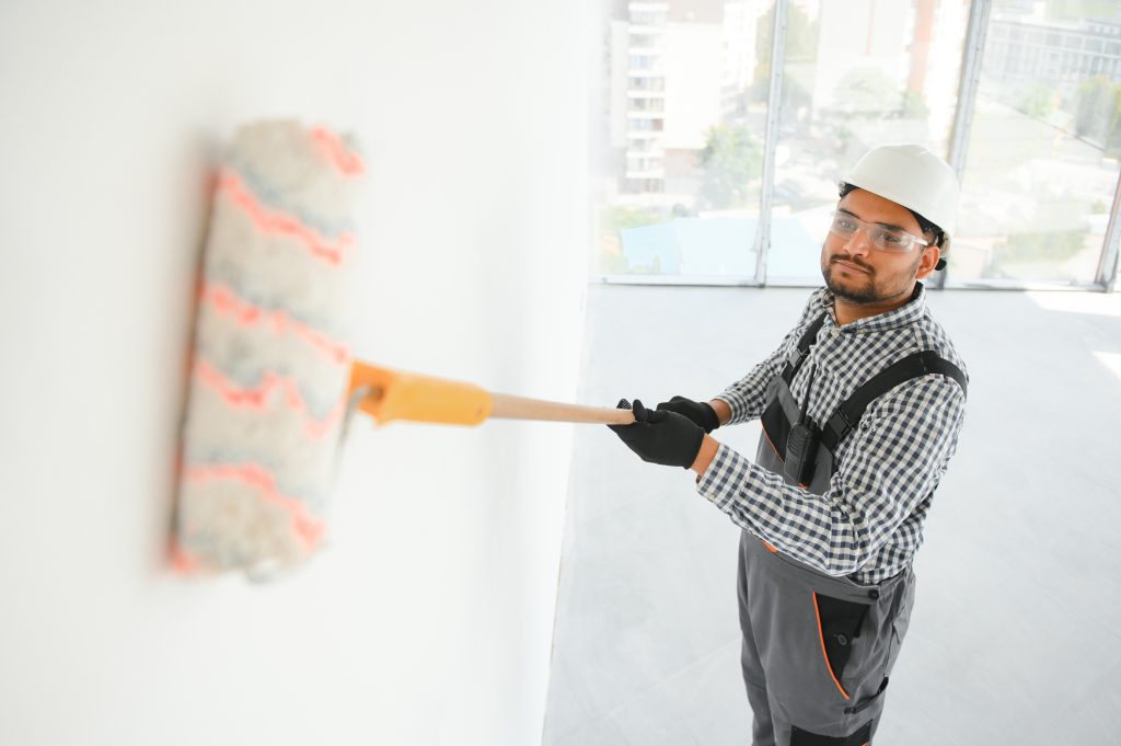 villa and commercial painting services Sharjah team painting facade on scaffolding