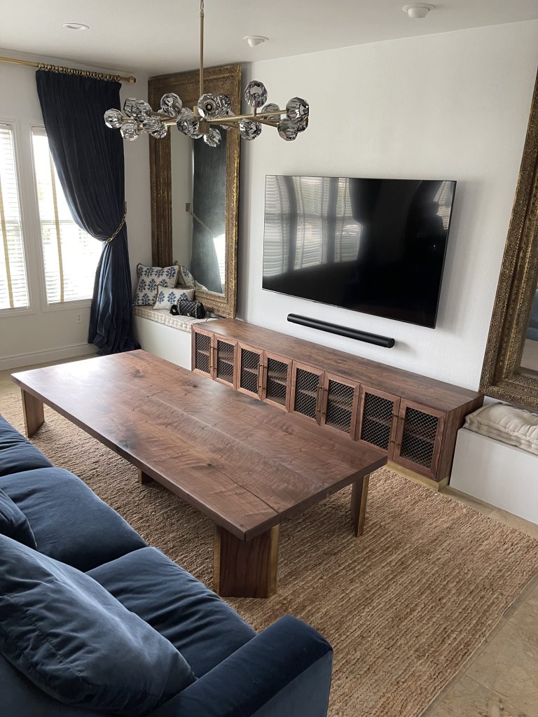 Smiling Dubai family admiring freshly assembled furniture in their living room, completed by vetted carpenters.