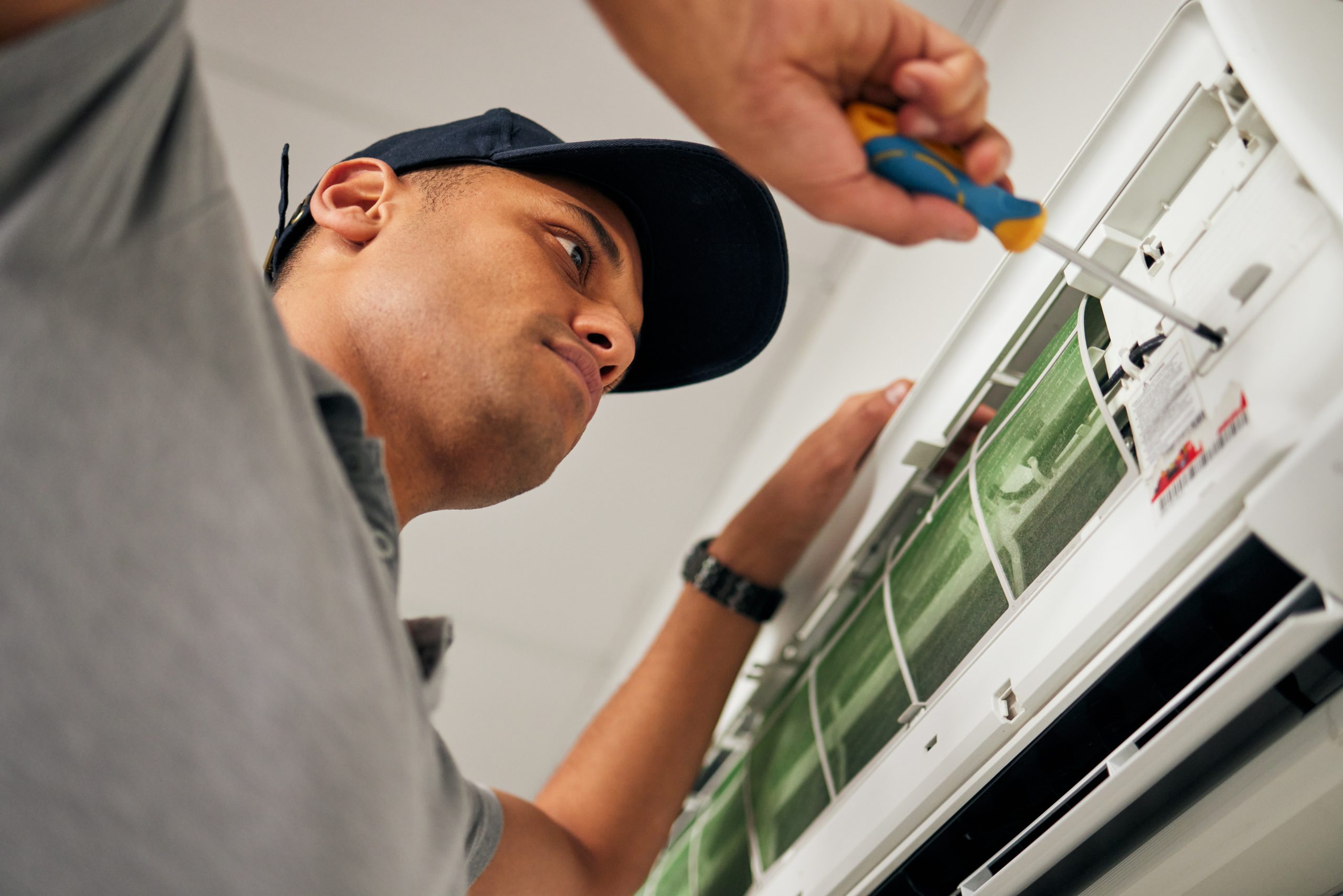 HVAC maintenance UAE technician inspecting AC components and evaporator coils.