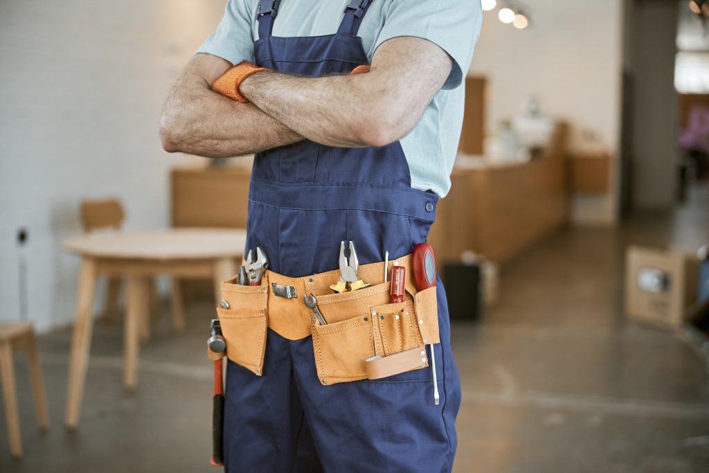 AC maintenance Sharjah same-day service technician holding maintenance tools inside home.