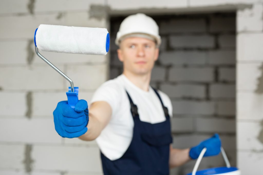 villa and commercial painting services Ajman team painting exterior facade on scaffolding