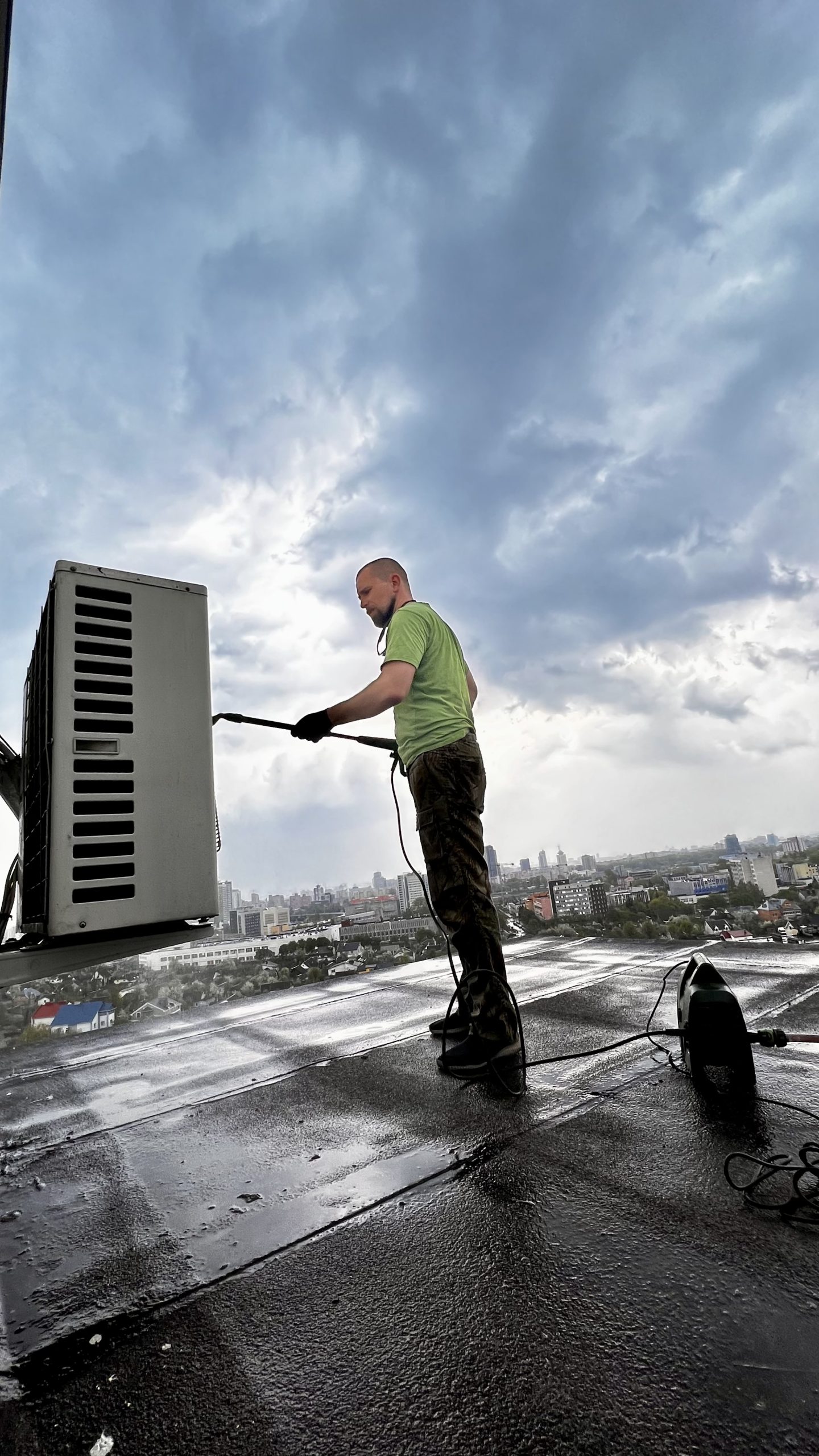 Licensed AC coil cleaning UAE technician cleaning rooftop commercial AC coils with specialized tools.