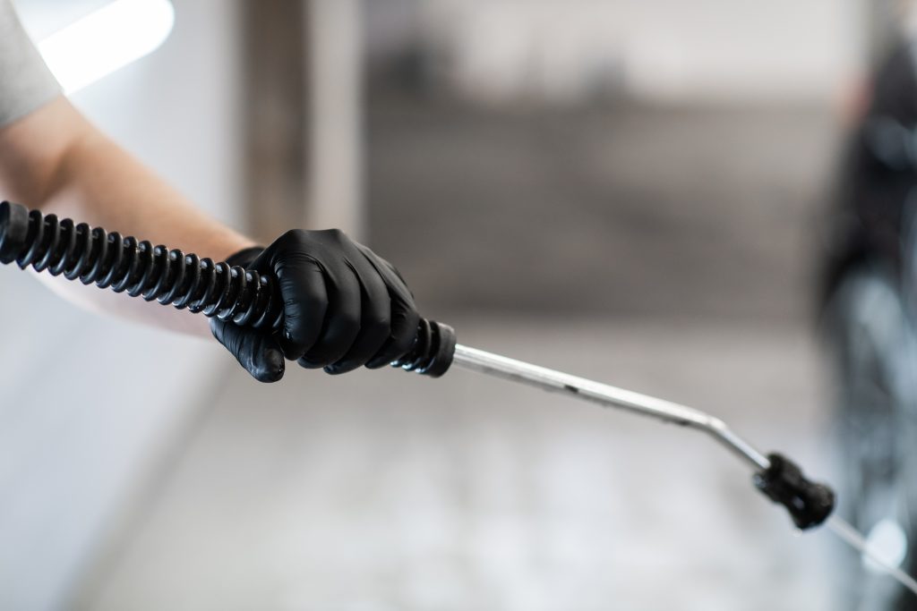 Affordable AC coil cleaning Ajman professional applying eco-friendly coil cleaning solution on an air conditioner.