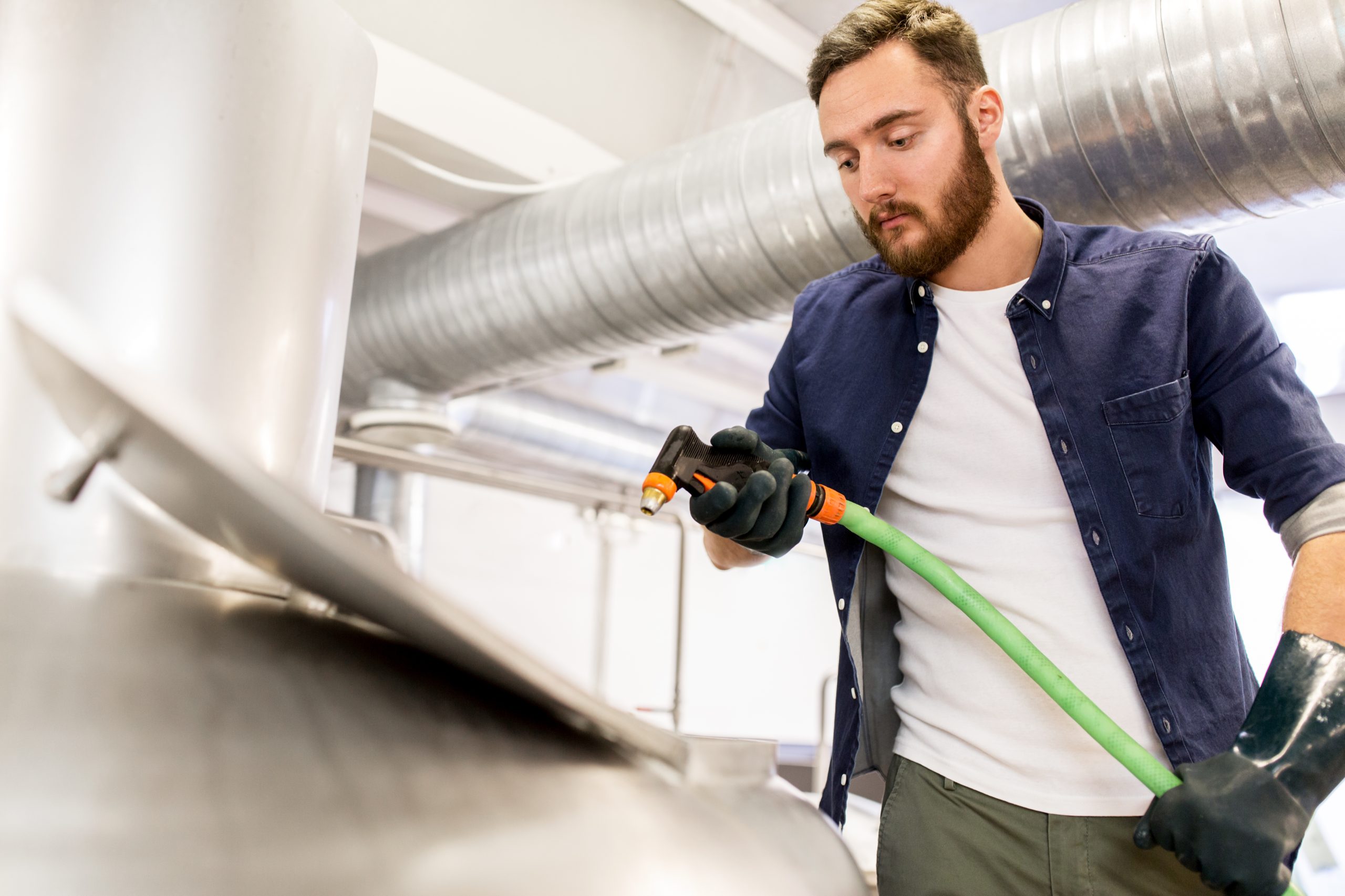 Dust storm AC cleaning Ajman - Technician performing duct deep cleaning with industrial vacuum tools.