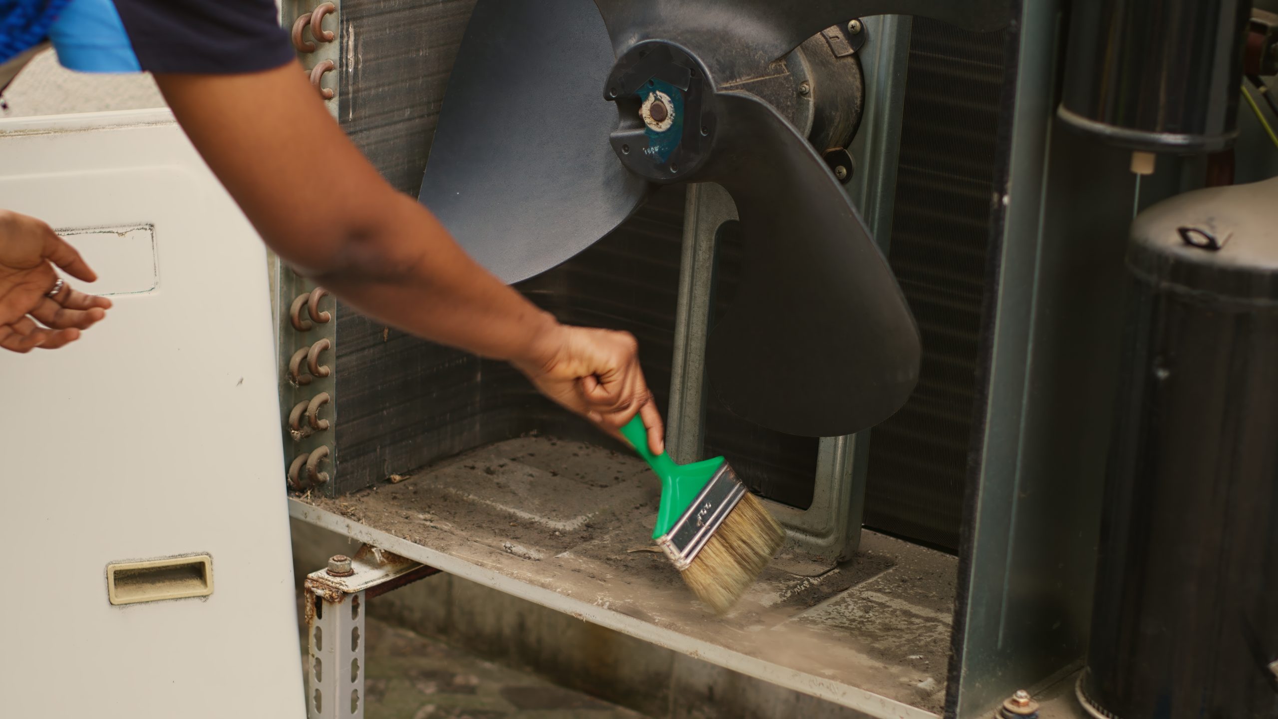 Licensed AC coil cleaning Sharjah technician brushing and rinsing evaporator coils for better airflow and hygiene.