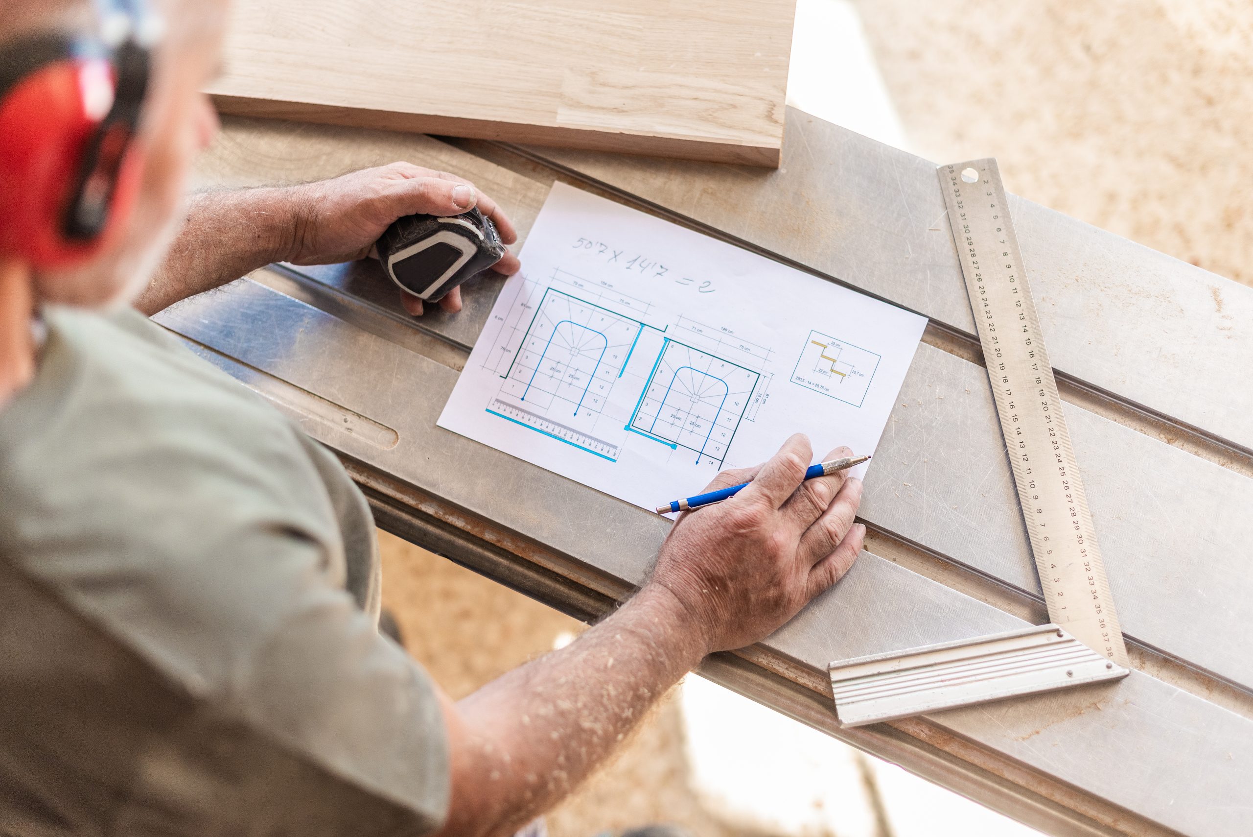 custom carpentry Sharjah consultation with carpenter showing design sketches