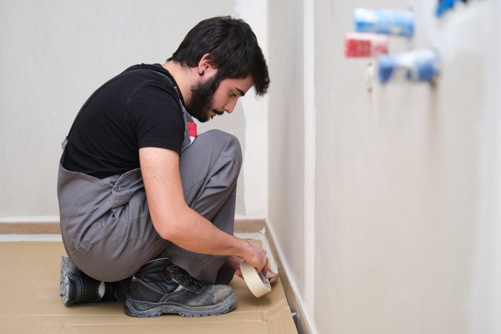 painter UAE applying smooth paint finish on interior feature wall