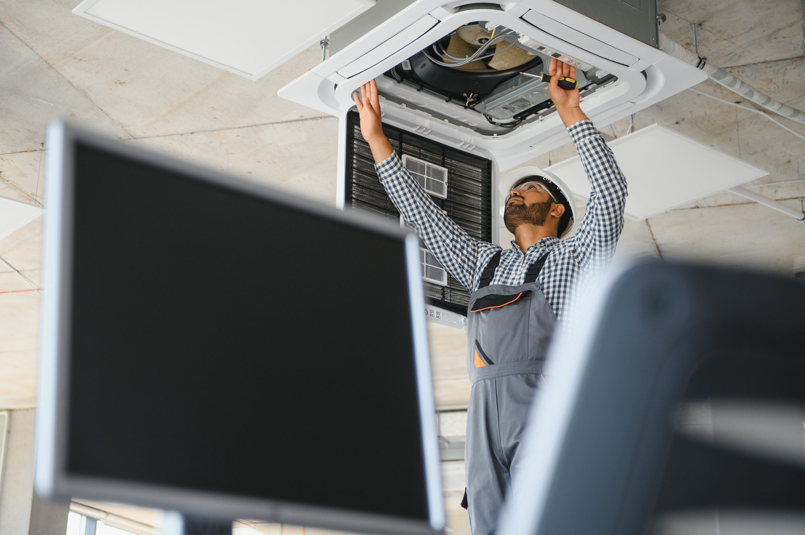 Professional AC servicing Abu Dhabi technician testing AC cooling output with digital tools.