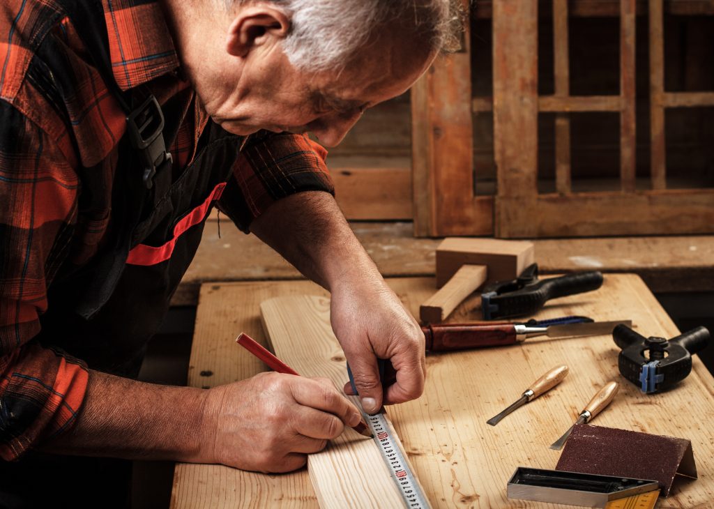 Carpenter in Dubai using an Allen key and instruction manual to assemble a bed frame, symbolizing reliable and hassle-free furniture assembly.