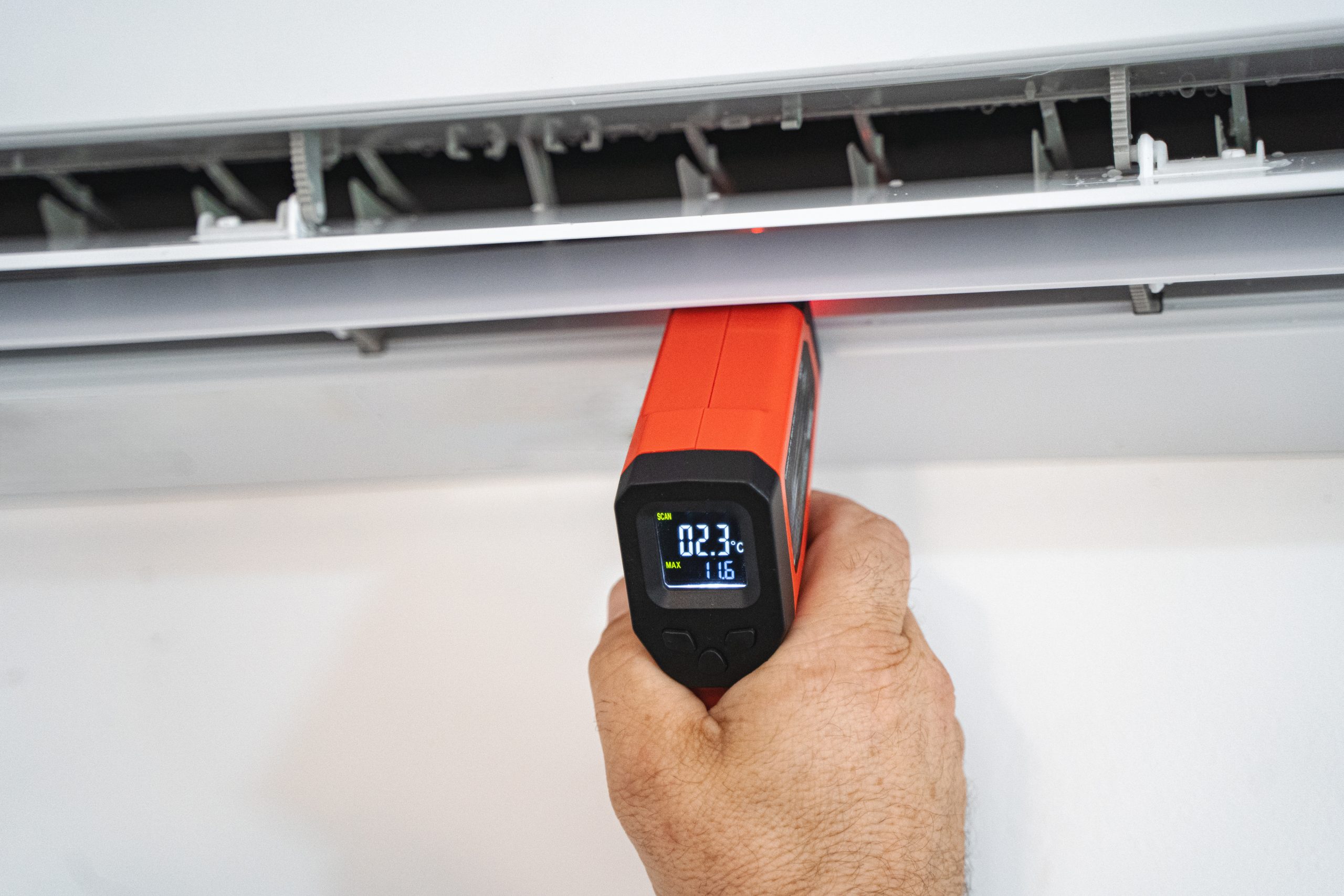 Air conditioner maintenance Ajman near me - Technician cleaning condenser coil with specialized tools.