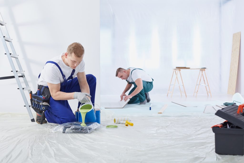 Painting contractors working on large living room space in Dubai.