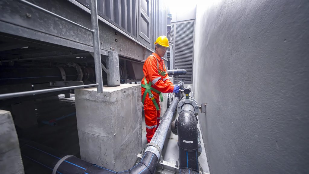 certified water tank disinfection Sharjah professional standing beside cleaned tank