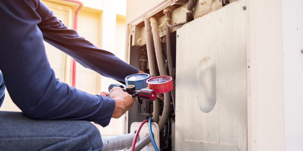 Technician in Sharjah showing clean and dirty AC coils side-by-side to a homeowner after professional coil cleaning.