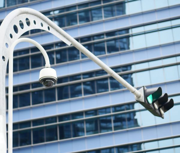 CCTV security camera operating outdoor against city buildings CCTV security camera operating outdoor ,