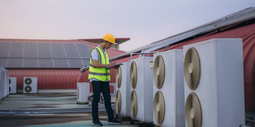 Licensed AC servicing Sharjah technicians repairing rooftop commercial AC systems.