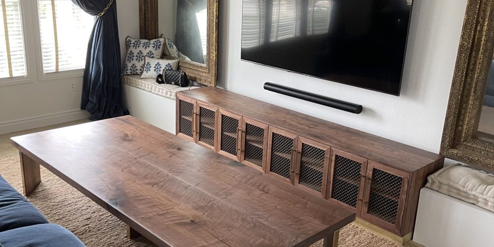 Smiling Dubai family admiring freshly assembled furniture in their living room, completed by vetted carpenters.