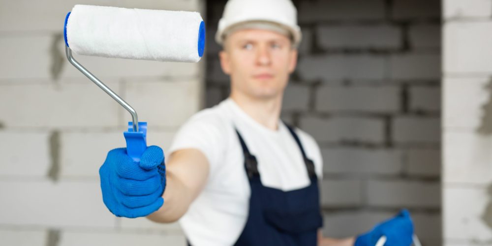 villa and commercial painting services Ajman team painting exterior facade on scaffolding