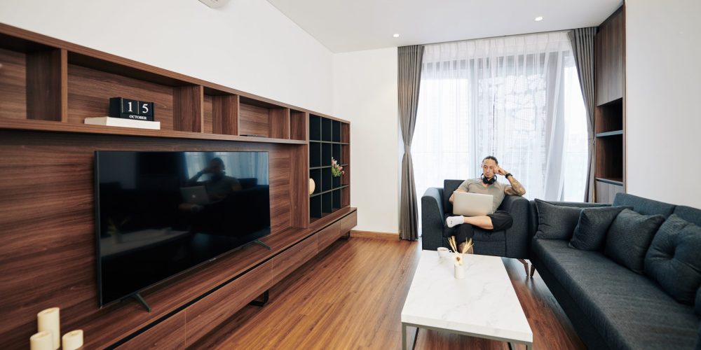 Dubai family relaxing in a bright living room with fresh airflow visuals, while technician in background closes a newly cleaned duct vent.
