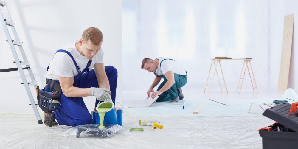 Painting contractors working on large living room space in Dubai.