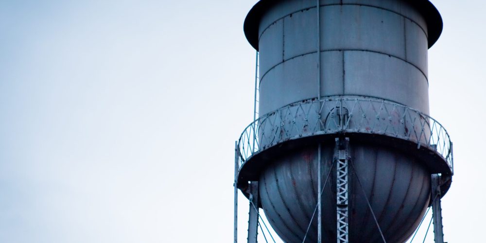 Water Tank Inspection & Pressure Cleaning Dubai Technician in Dubai pressure-washing the inside of a water tank with protective gear, removing sediment and buildup.