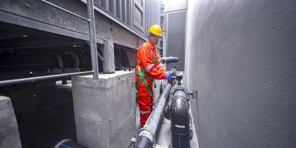 certified water tank disinfection Sharjah professional standing beside cleaned tank